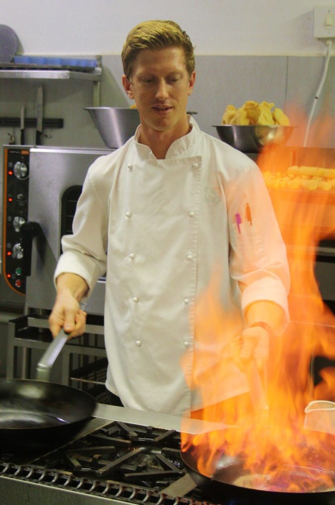 Chef Jarred Pullin creating flames at Rhino Ridge Safari Lodge